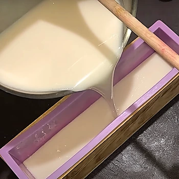 Pouring half of the melted mixture in the soap mold