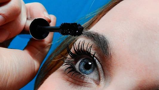 DIY Serum for Thicker Eyelashes. Woman applying serum to eyelashes